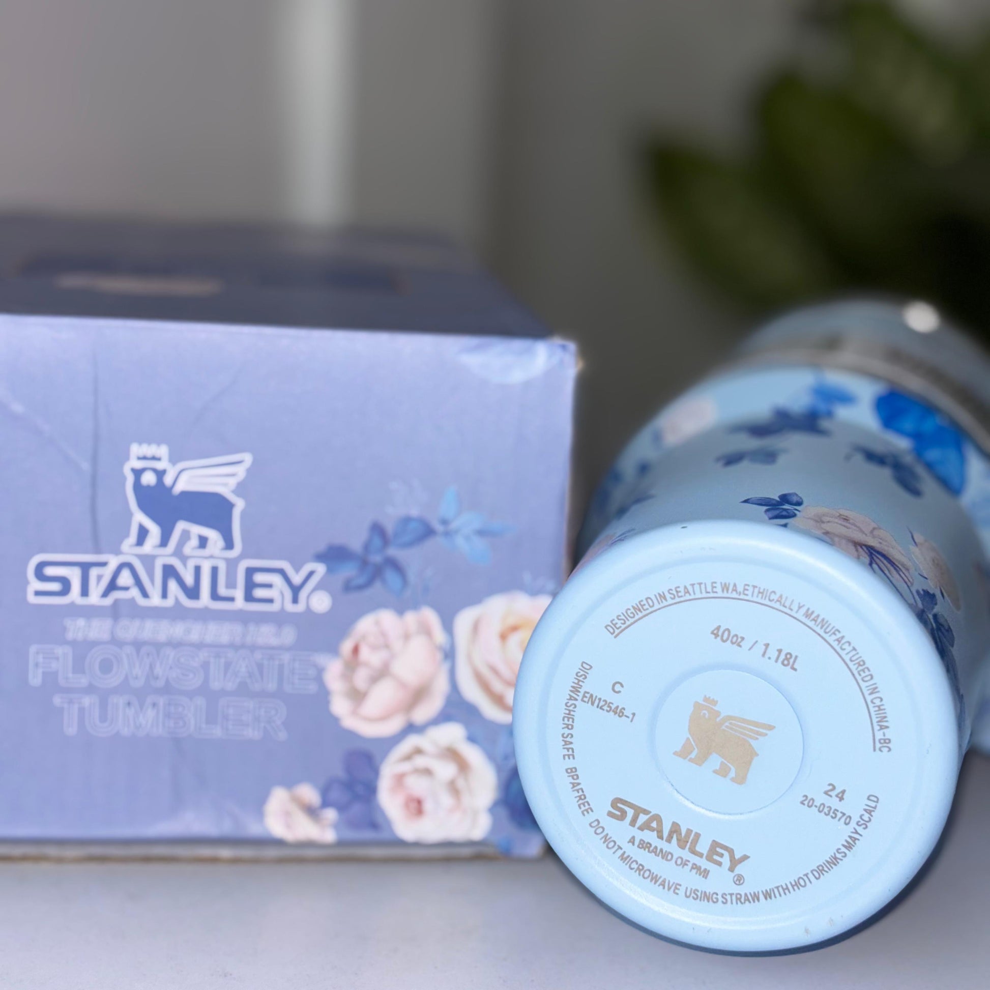 Bottom view of a Stanley FlowState tumbler with floral design next to its packaging.