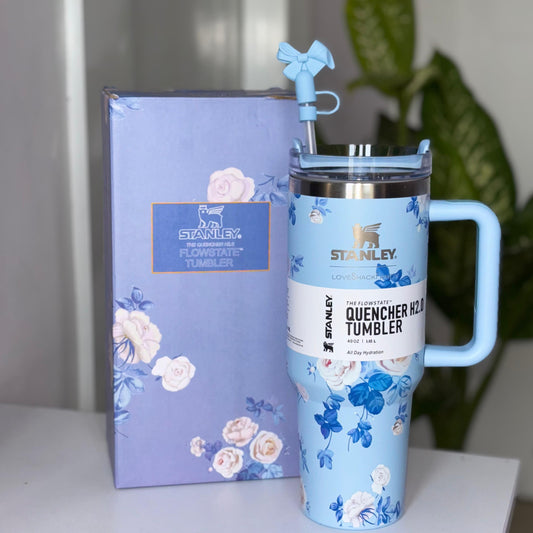 Stanley Quencher H2.0 Tumbler with floral design, handle, and FlowState lid, placed beside its packaging.